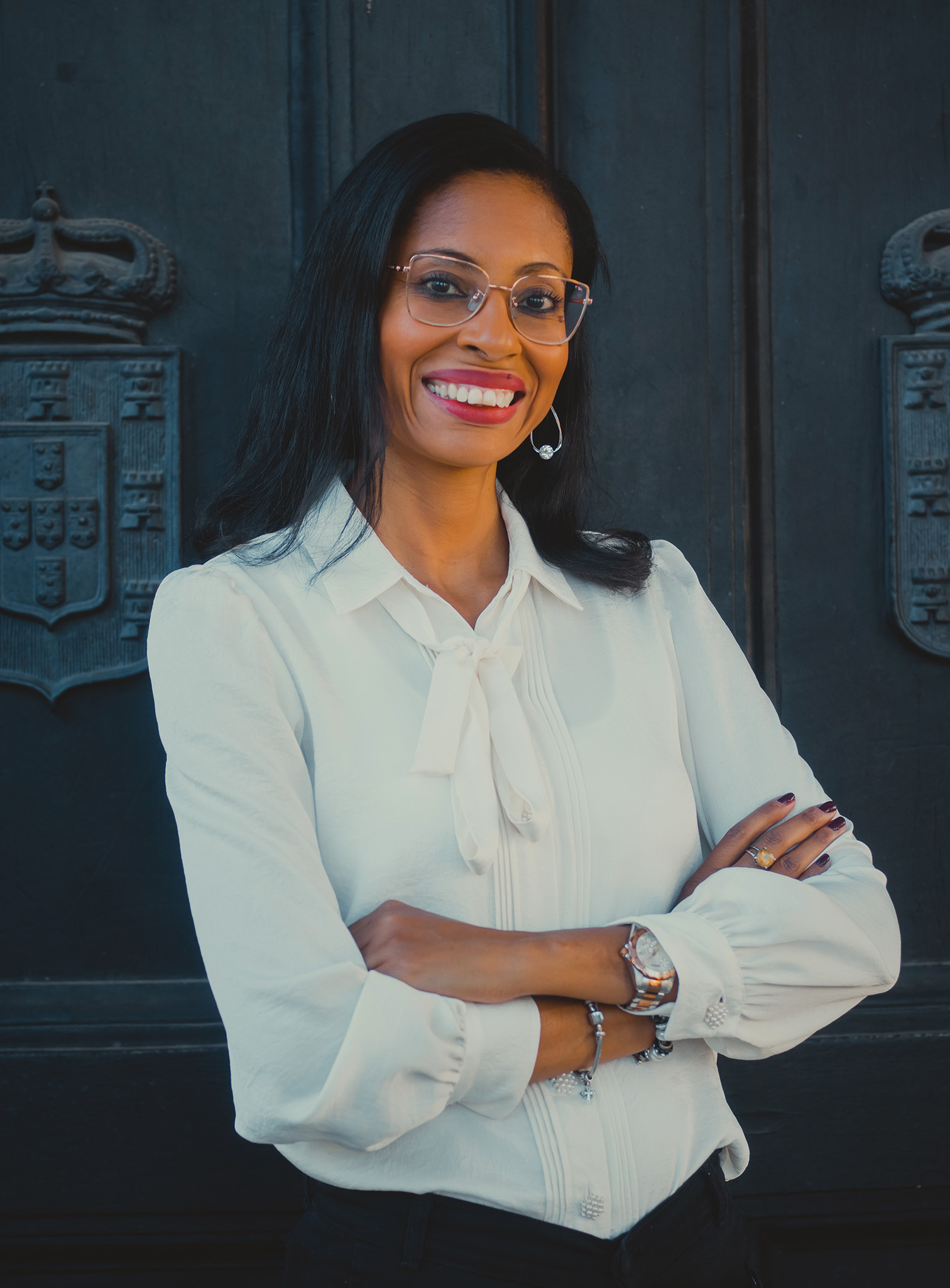 Thais Reis, advogada, junto a uma porta de madeira